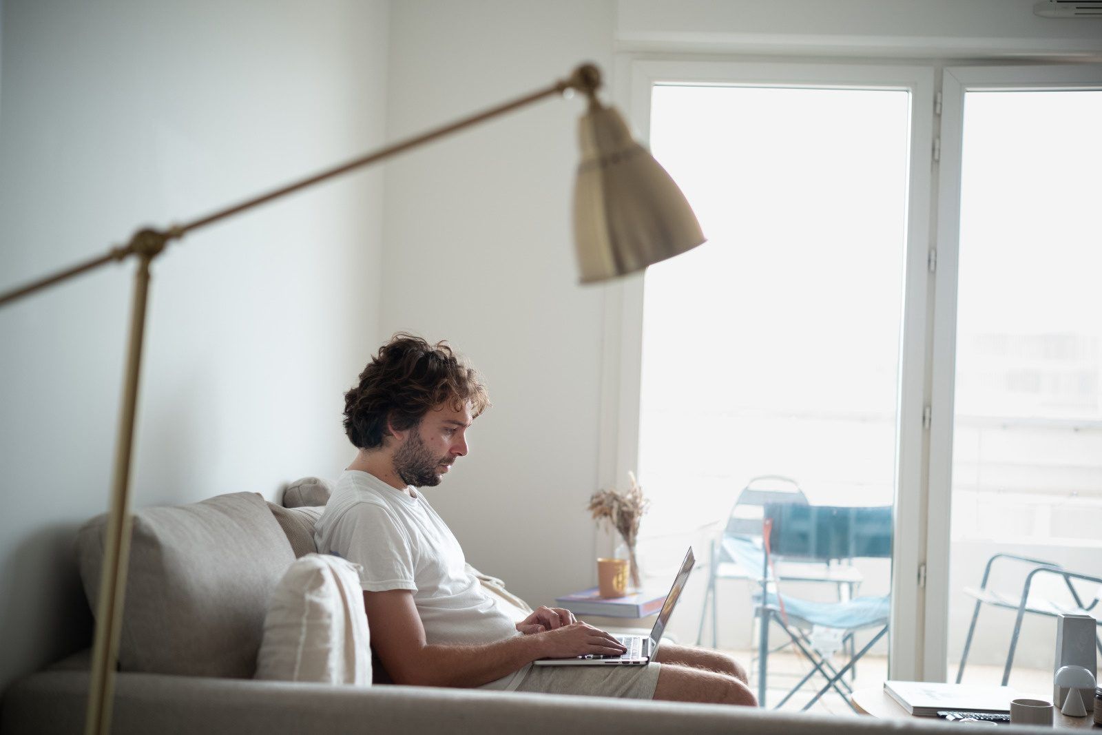 un homme assis entrain de tapoter sur son ordinateur